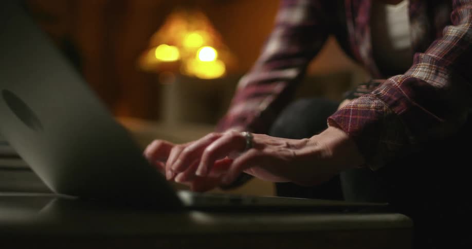 A man is using a laptop while sitting on a couch