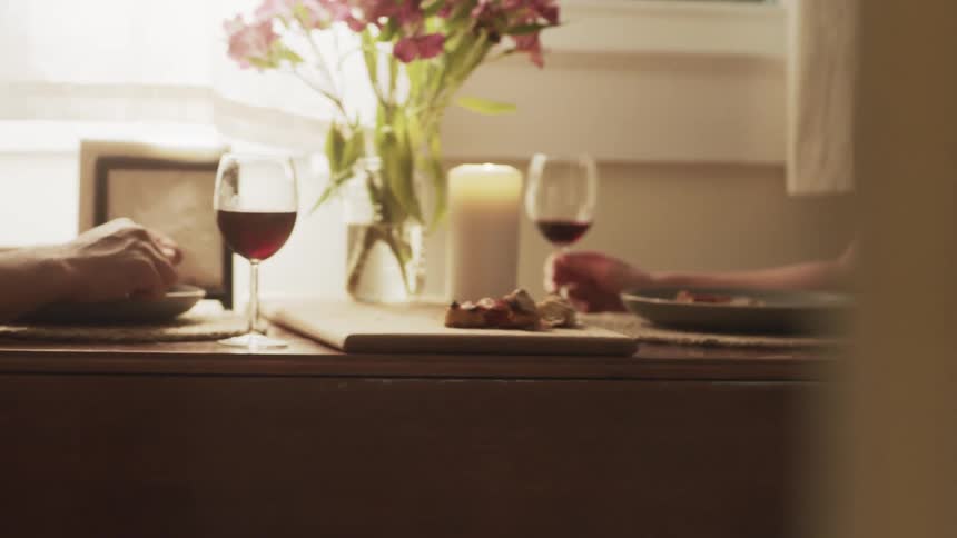 A man and a woman sitting at a table with a candle and wine glasses