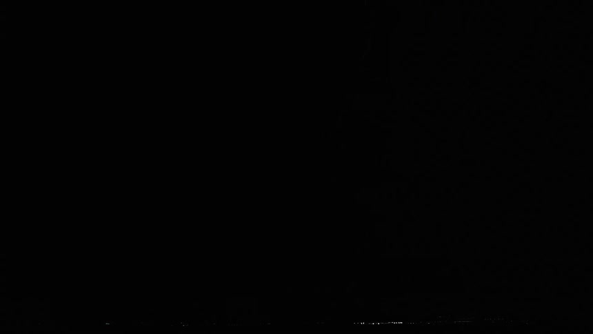 Veins of lightning spread downward from the nighttime sky before striking the ground and sending a flashing bolt back upwards towards the clouds