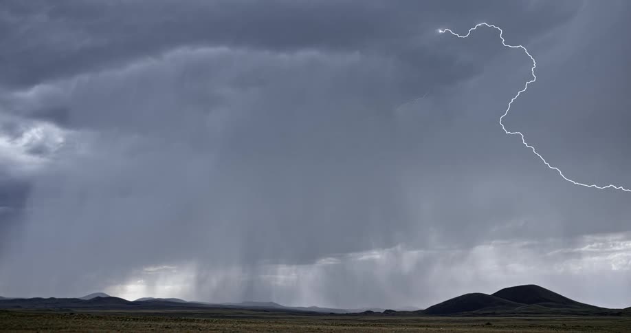 Lightning bolts flash and branch out over a mountain range
