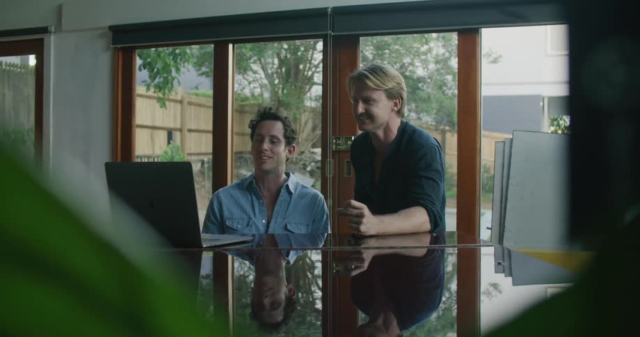 Two inspired men playing music on a piano at home
