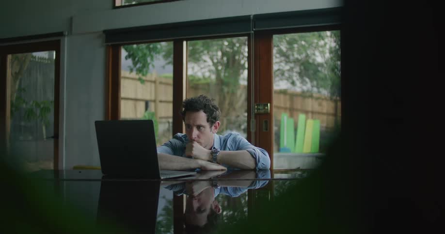 A man is sitting at a table with a laptop