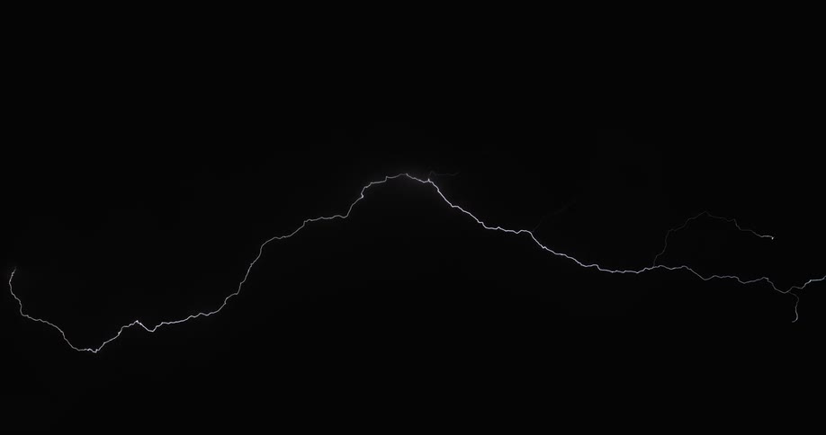 A flash of lightning moves across a dark sky in a thunderstorm at nighttime