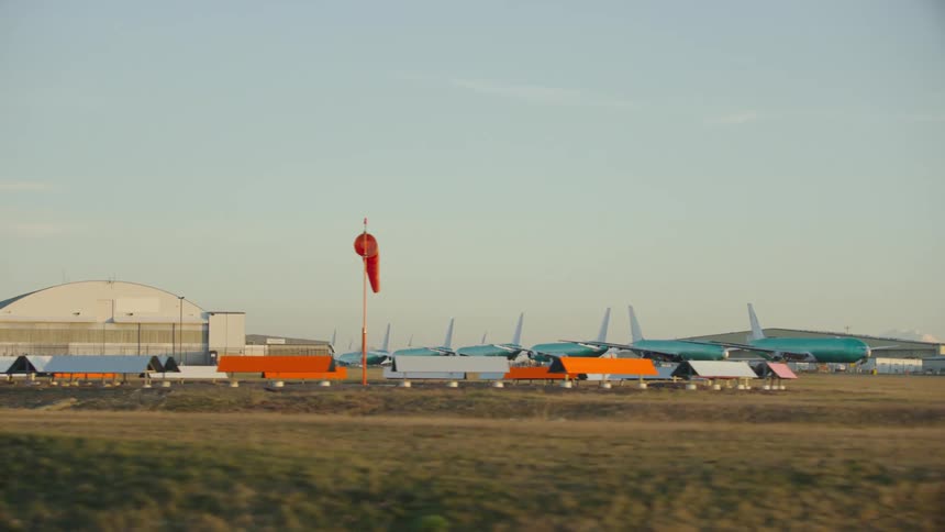A windsock hangs at a large commercial airport with Boeing 777 aircraft under final construction at the Boeing manufacturing facility in Washington State