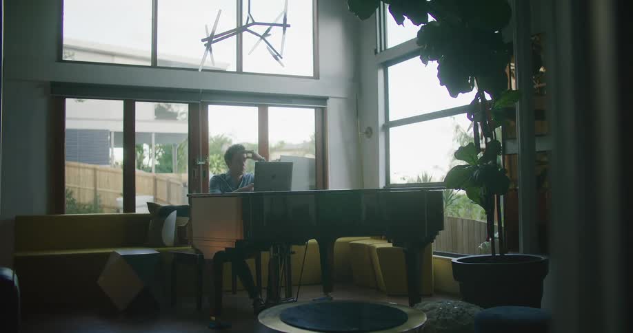 Man playing piano on the living room at home