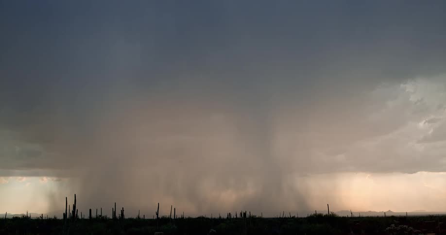 Numerous bolts of lightning strike the ground beneath dark storm clouds as the rain falls
