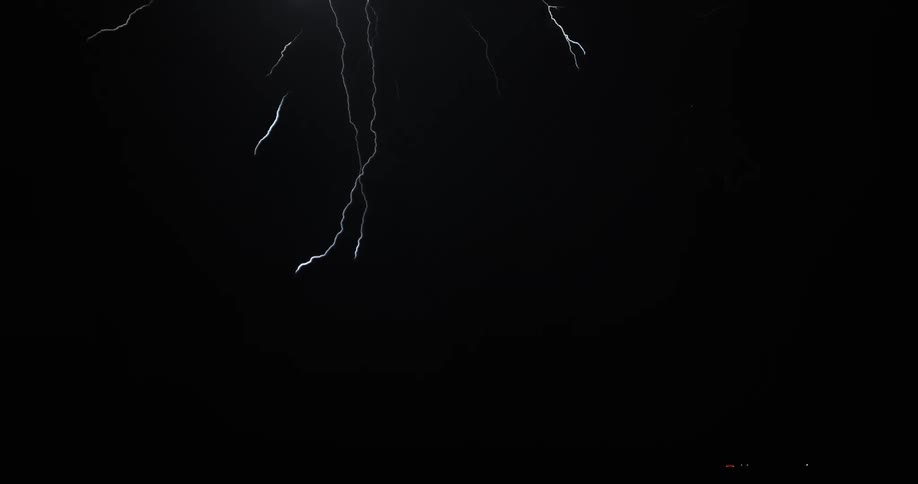 Lightning streaking arcs flash before hitting ground at night