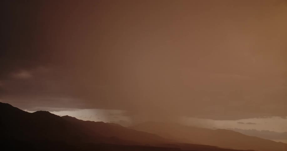 Lightning strikes in from the left in a storm cloud sky in the evening