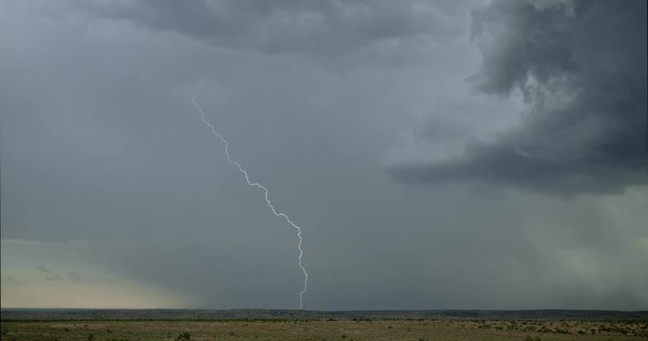 Lightning bolt flashes across the sky and hits the ground