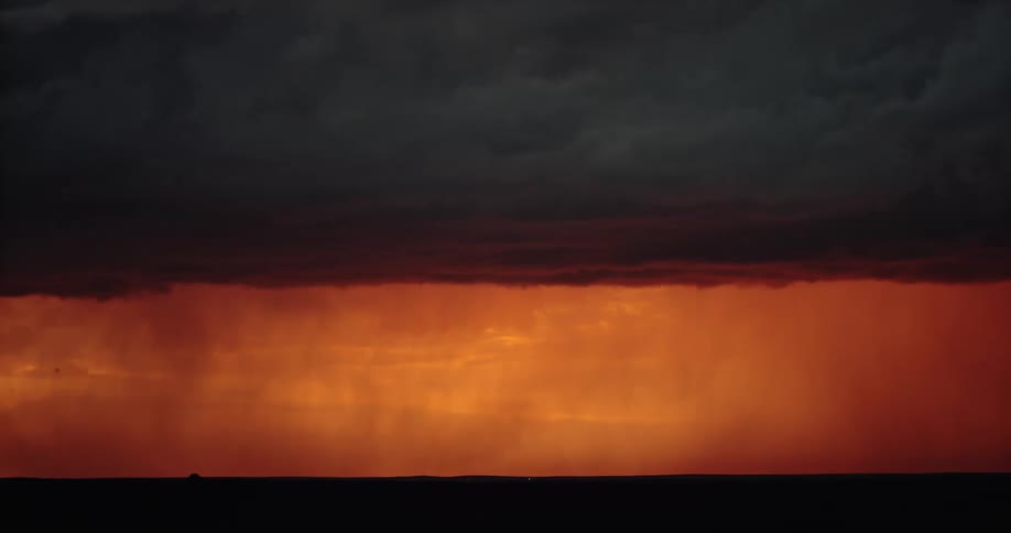 Lightning flashing in an orange sky during a rainstorm