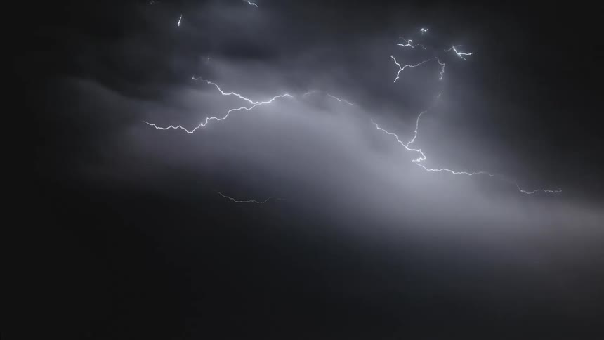 Lightning illuminating a cloudy night sky during a storm
