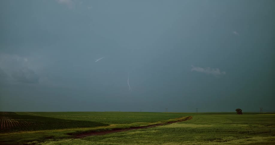 A landscape with a storm with lightning in the sky and clouds in the background