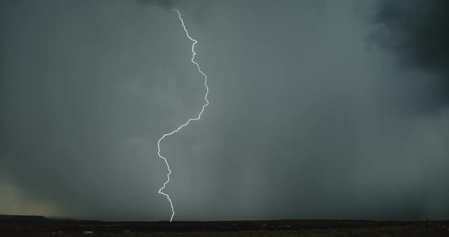 Lightning streaking arcs flashing accross yellow storm clouds