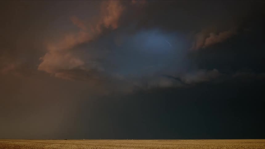 Lighting bolts flashing behind a cloud in the desert during a lighting storm