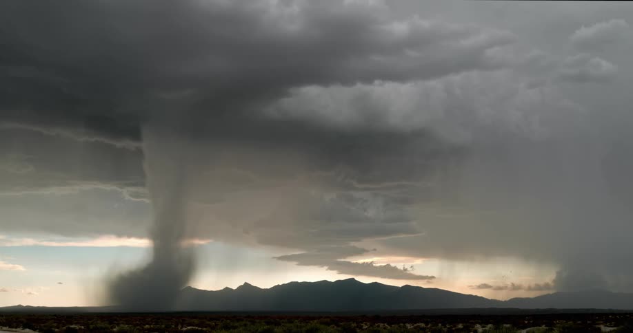 A tornado and lightning strikes in a vast grassland on a cloudy day