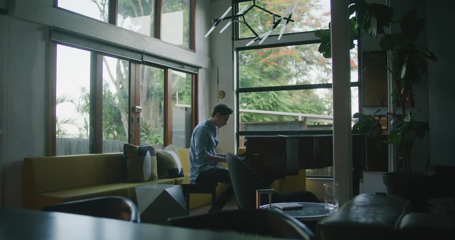 A man playing a piano in a house