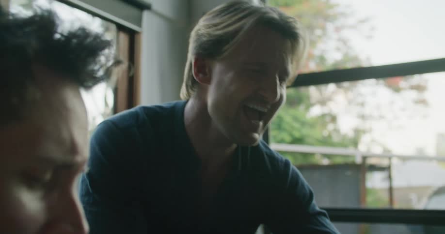 Two men playing piano and singing along in a room at home