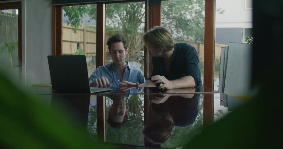 Two workers working on something at a laptop