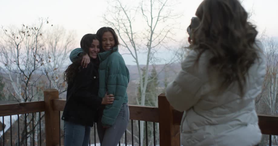 Two women pose for a photograph outside