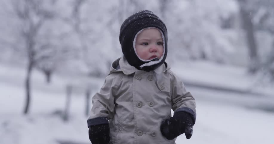 A toddler walking in snowfall