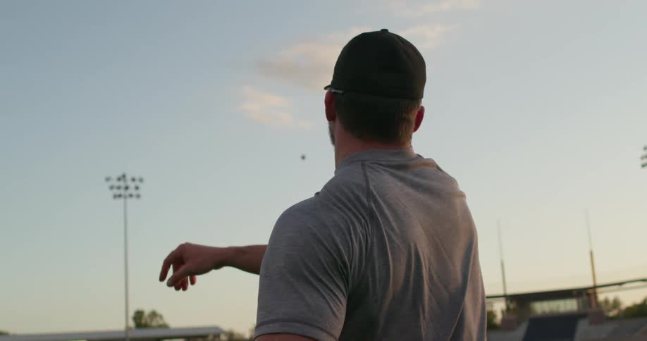A man in a stadium throws a baseball