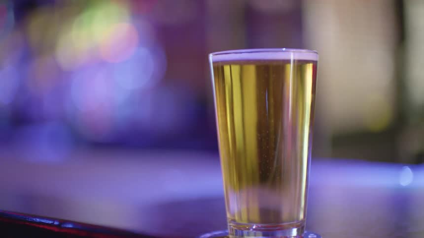 A cup of yellow beer on a bar counter in a club