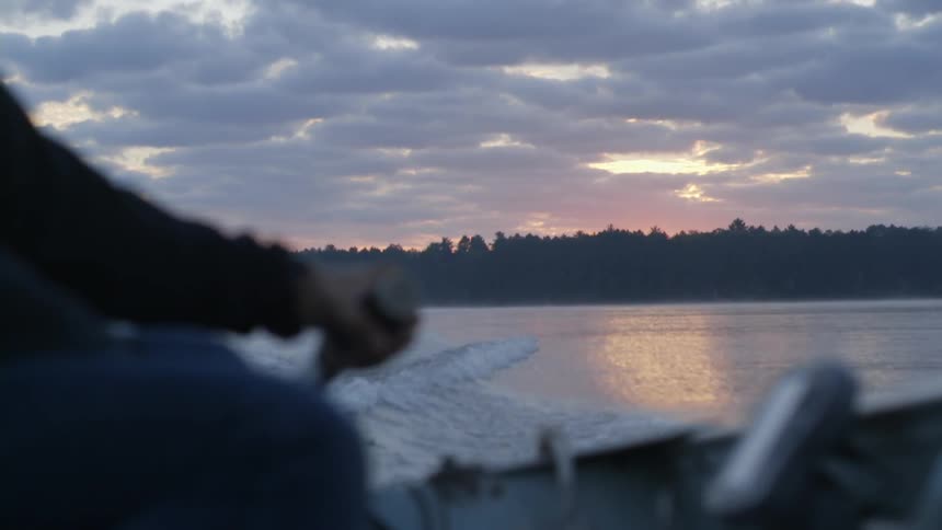 Man rides a boat across a lake