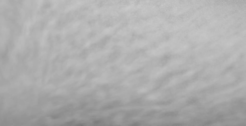 Water droplets covered in white dust vibrating over a surface