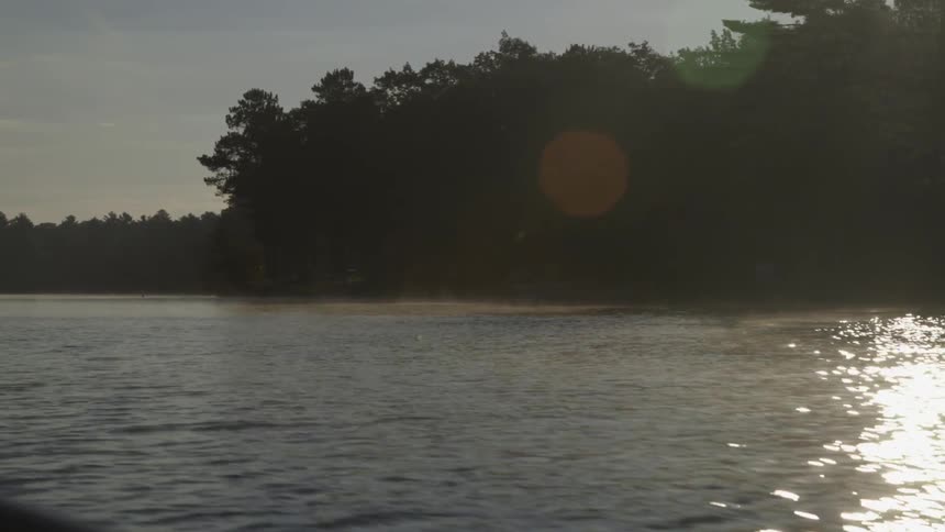 Moving over a lake lined with a forest