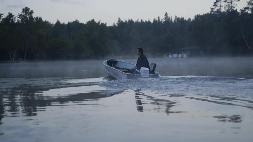A person drives a boat on a lake