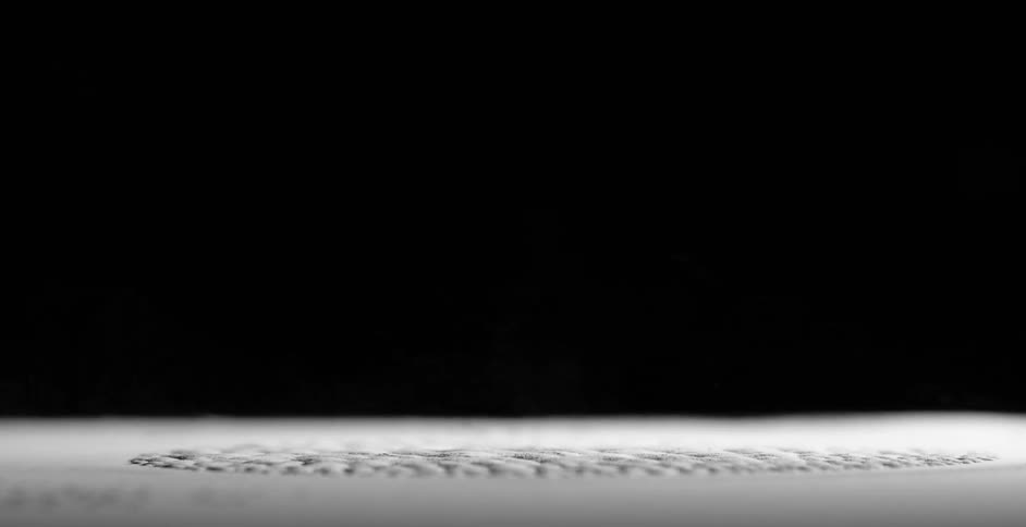 A white powder spins in a centrifuge and settles into a patterned shape after stopping