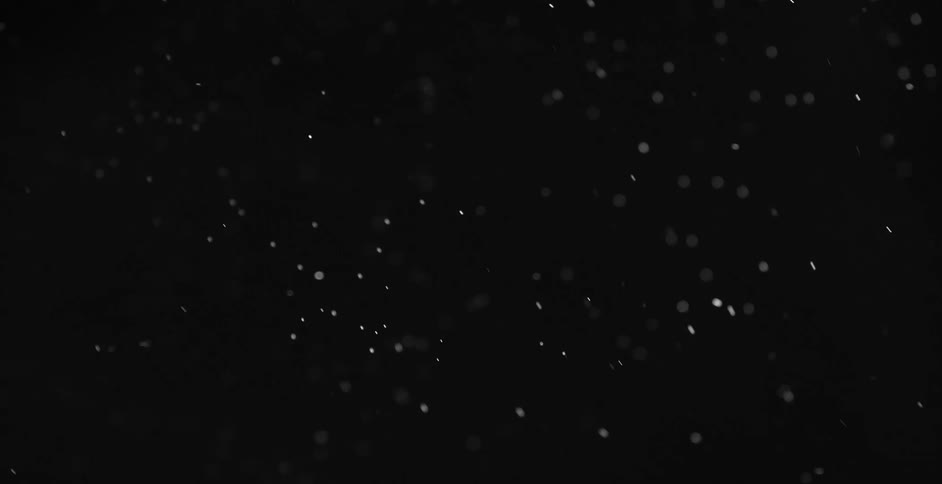 White particles rise and swirl against black