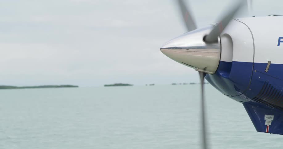 Propeller of plane spins against shore across water