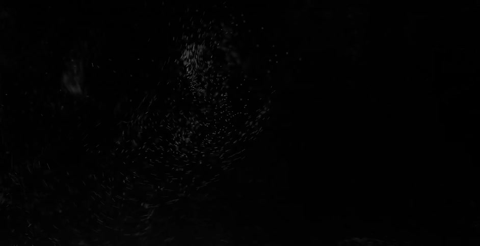 White dust twirling in the air in front of a black background
