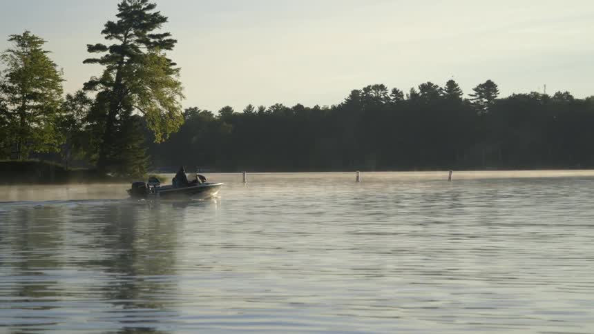 A boat is moving over some water on a cloudy day