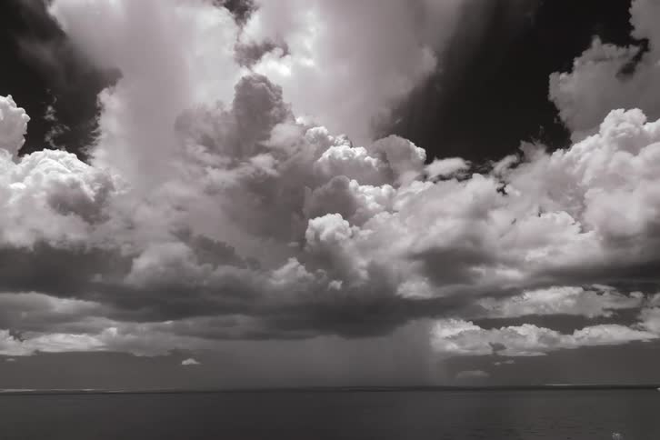Storm and rain clouds gather and swirl over the water