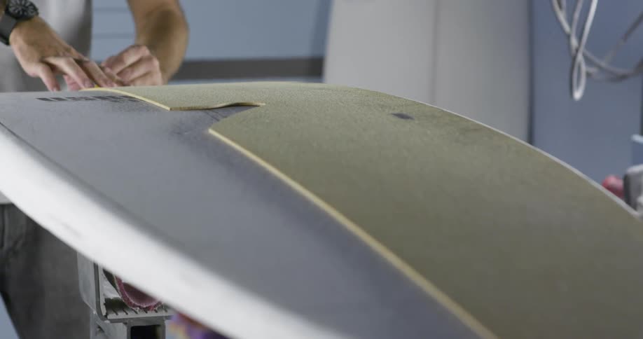 Person traces shape onto surfboard