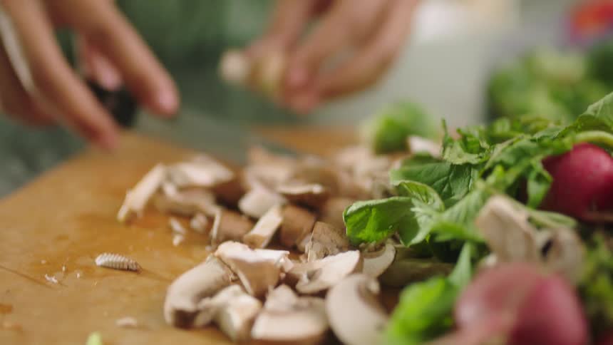 A woman chops mushrooms at home