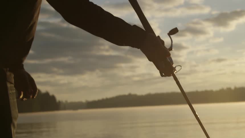 A man twists his fishing rod in the water
