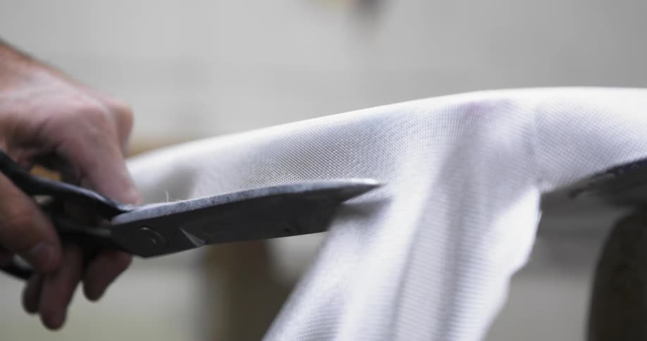 A man cuts material in a shop
