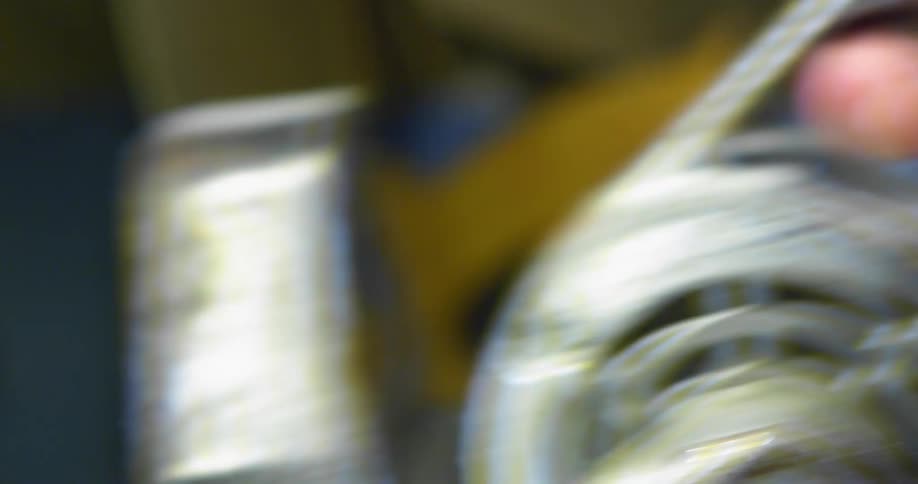 A man grabs the handle of a metal saw in his workshop