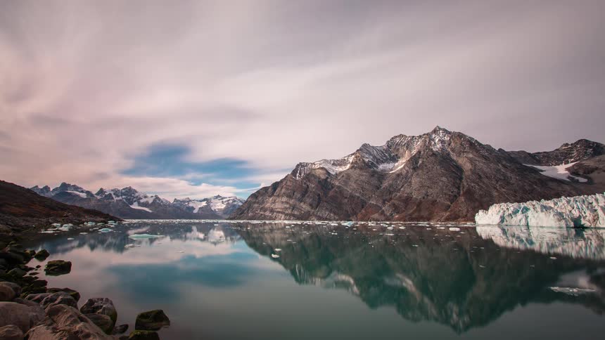 Mountain range with lake reflecting the clouds moving across the sky