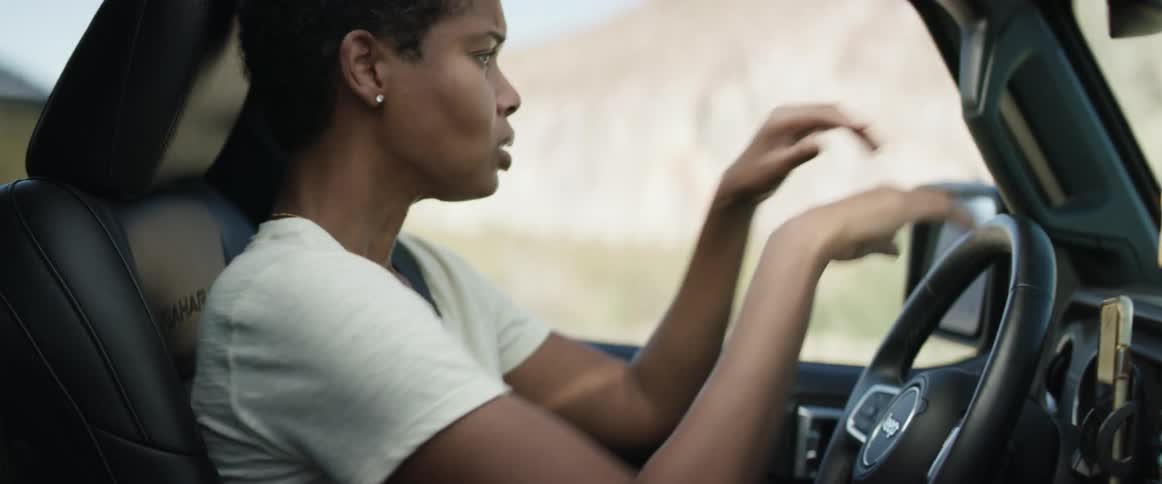 A woman sitting in a vehicle throws a map in frustration before holding her forehead and crying