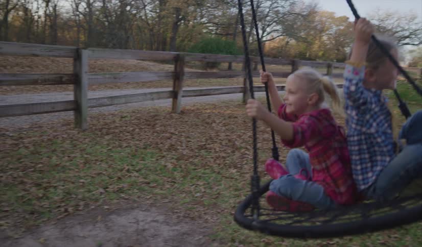 A father pushing his daughters on a swing