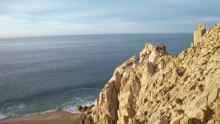 Coastal rock formation along beach shoreline on a cloudy day