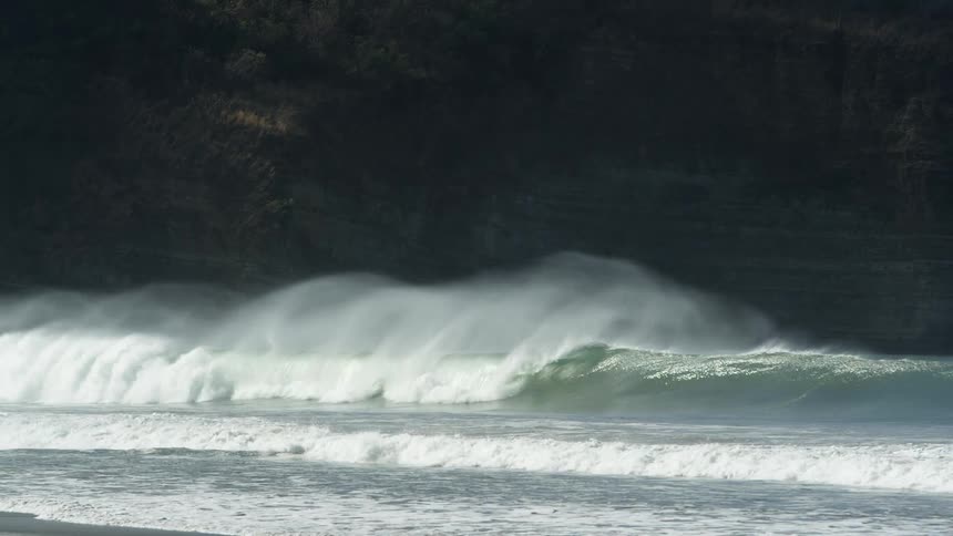 Waves are rolling in under a dark sky