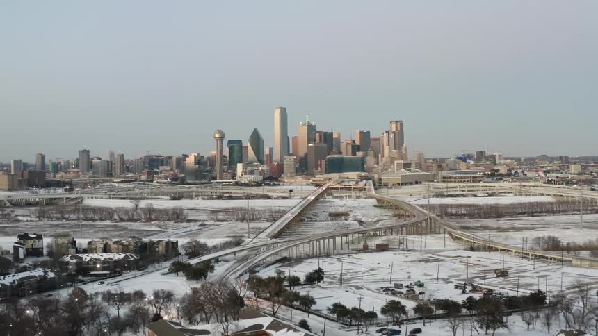 Snow covers the ground on the highway and neighborhoods near downtown