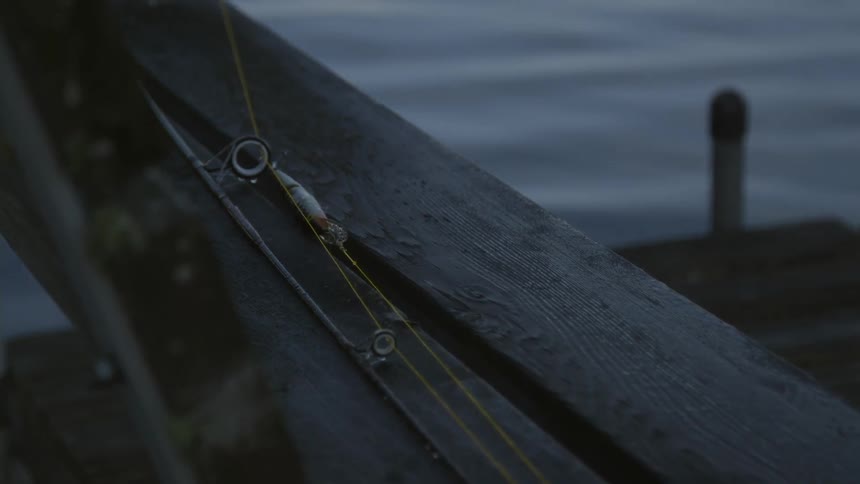 Close up of part of a fishing pole next to water