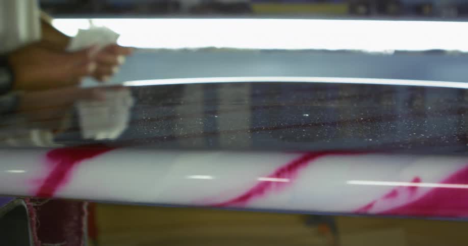 A man polishes a surfboard