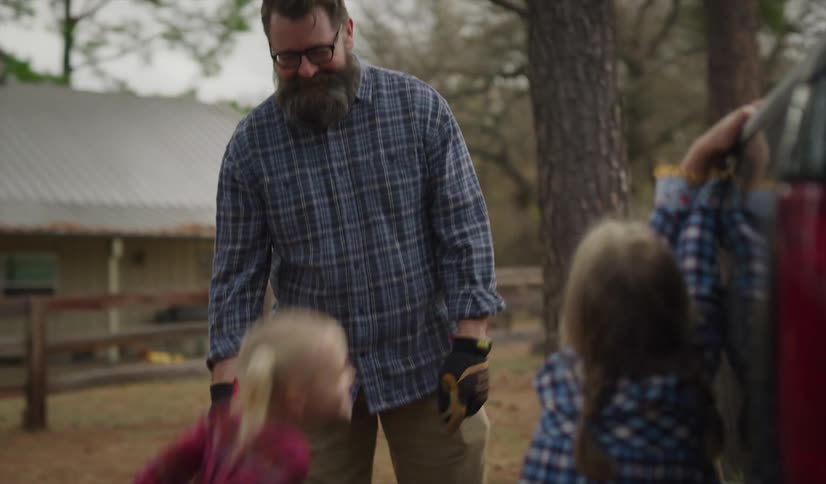Father teaching daughters how to close the door on the back of a truck